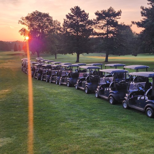 Sunset on golf course with carts lined on cart path